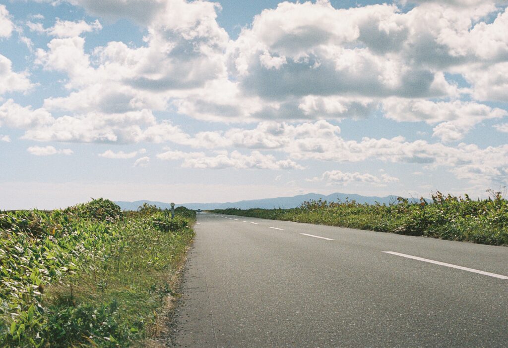 雲の広がる空と、まっすぐ伸びる道路