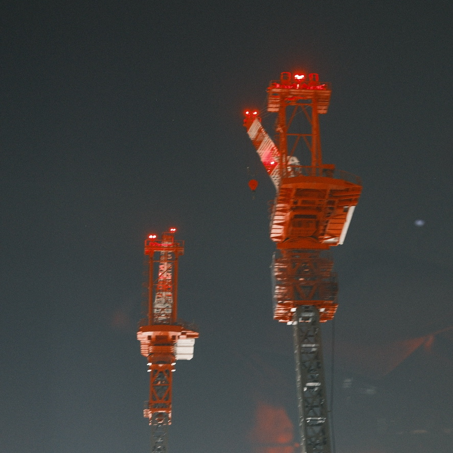 夜空に浮かぶ赤い照明のクレーン