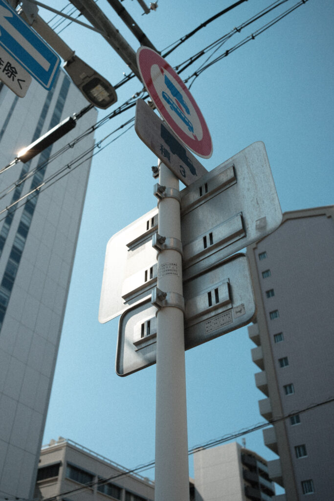 見上げた角度で撮った道路標識と電線